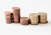 Stacks of copper and gold coins arranged in ascending order on a white background.